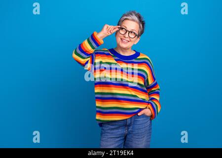 Photo de lunettes tactiles intelligentes de bras de dame d'esprit regardent l'espace vide intéressé isolé sur fond de couleur bleue Banque D'Images