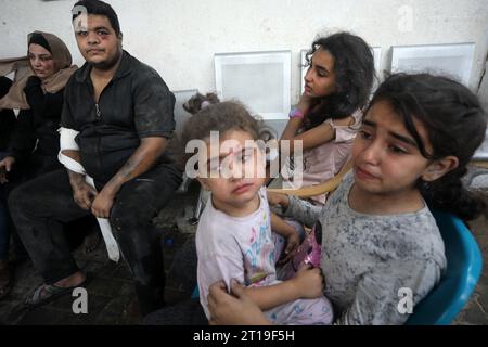 Rafah, Gaza. 11 octobre 2023. Des enfants palestiniens blessés attendent à l’hôpital pour être contrôlés, suite à une frappe israélienne contre leur maison à Rafah, dans le sud de la bande de Gaza, alors que les frappes israéliennes meurtrières se poursuivent pour la sixième journée consécutive jeudi. 12 octobre 2023. Photo par Ismael Mohamad/UPI crédit : UPI/Alamy Live News Banque D'Images