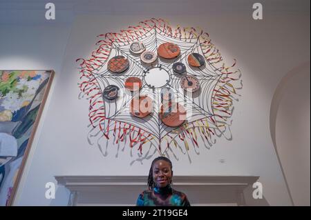 Somerset House, Londres, Royaume-Uni. 12 octobre 2023. 1-54 Contemporary African Art Fair se déroule pendant la semaine Frieze du 12 octobre au 15 octobre avec plus de 170 artistes travaillant à travers un éventail de médiums allant de la peinture et de la sculpture aux médias mixtes et à l'installation représentés. La Foire se tient pour la quatrième année en partenariat avec la maison de vente aux enchères Christie’s. Image : l'artiste Anne Adams avec son œuvre de médias mixtes Web of existence, 2021. Crédit : Malcolm Park/Alamy Live News Banque D'Images