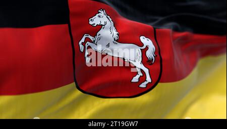 Gros plan du drapeau de l'État de Basse-Saxe brandissant. Rayures noires, rouges et jaunes avec blasons au centre. État allemand. rendu d'illustration 3d. Sélection Banque D'Images