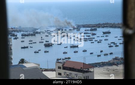 De la fumée s'écoule d'un bateau après une frappe israélienne sur le port de Gaza City de la fumée s'écoule d'un bateau après une frappe israélienne sur le port de Gaza City le 12 octobre 2023. Photo de Salah Abbas apaimages ville de Gaza bande de Gaza territoire palestinien 121023 Gaza sa 1 001 Copyright : xapaimagesxSalahxAbbasxxapaimagesx Banque D'Images