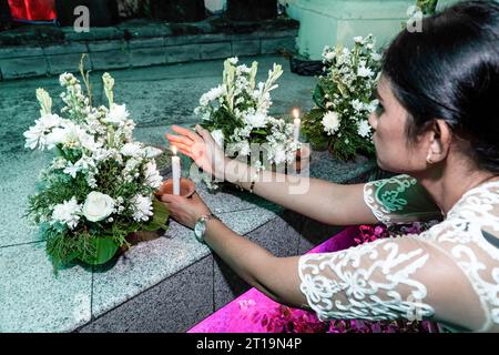 Badung, Indonésie. 12 octobre 2023. Une femme allume une bougie comme veillée pour les victimes au mémorial du gorund zéro. Bali pour commémorer le 21e anniversaire de l'explosion consécutive connue sous le nom d'attentat de Bali, qui a tué 202 personnes de différentes nationalités dans la région de Legian. Crédit : SOPA Images Limited/Alamy Live News Banque D'Images