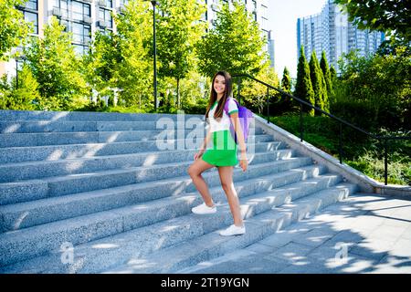 Photo de joyeuse fille brillante mignonne habillée de vêtements élégants allant à l'université premier septembre temps chaud d'automne à l'extérieur Banque D'Images