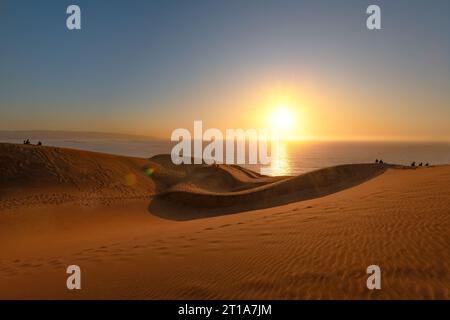 Les gens regardent le coucher du soleil depuis le champ de dunes de Concon, Chili Banque D'Images