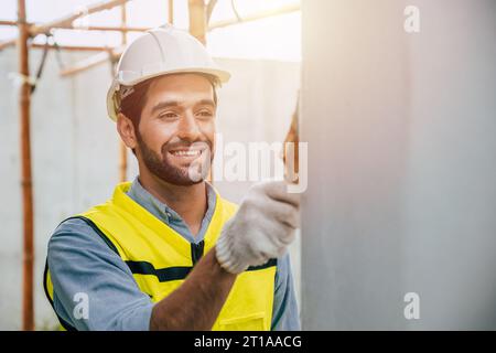 travailleur masculin peinture murale couleur maison rénover heureux sourire profitez de travailler Banque D'Images