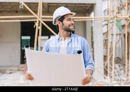 Travaux de constructeur d'ingénieur de construction sur le chantier de construction. Architecte chef de projet de maison chef concepteur heureux avec le plan d'étage. Banque D'Images