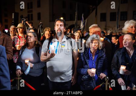 Munich, Allemagne. 12 octobre 2023. Les gens tiennent des bougies lors d'un service commémoratif de la communauté juive de Munich et de haute-Bavière devant la synagogue principale de Munich, Ohel Jakob. La commémoration a eu lieu sous la devise «deuil aux côtés d'Israël». Crédit : Matthias Balk/dpa/Alamy Live News Banque D'Images