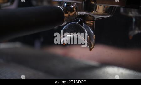 Le café vidéo s'écoule de la machine dans la tasse. Expresso chaud fait maison. Du café fraîchement moulu coule. Un barista prépare le café dans un café Banque D'Images