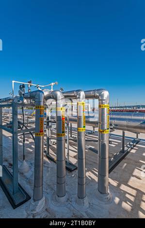 Tuyauterie isolée métallique réfléchissante sur le toit d'une installation de stockage frigorifique (réfrigération industrielle). Banque D'Images