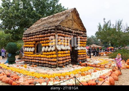 Dallas, États-Unis. 12 octobre 2023. Une fille se tient devant une maison de citrouilles dans le village de citrouilles de l'Arboretum de Dallas, Texas, États-Unis, le 12 octobre 2023. Le célèbre village de citrouilles de Dallas arboretum présente des maisons de citrouilles et des expositions créatives conçues à partir de plus de 100 000 citrouilles, gourdes et courges. Crédit : Dan Tian/Xinhua/Alamy Live News Banque D'Images