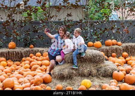 Dallas, États-Unis. 12 octobre 2023. Une femme prend un selfie dans le village de la citrouille de l'Arboretum de Dallas, au Texas, aux États-Unis, le 12 octobre 2023. Le célèbre village de citrouilles de Dallas arboretum présente des maisons de citrouilles et des expositions créatives conçues à partir de plus de 100 000 citrouilles, gourdes et courges. Crédit : Dan Tian/Xinhua/Alamy Live News Banque D'Images