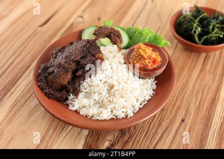 Nasi Bebek Madura, riz à la sauce noire de canard avec épicé Sambal Bawang. Sur la table en bois Banque D'Images