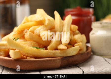 Délicieuses frites servies avec des sauces sur table, gros plan Banque D'Images