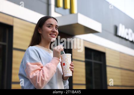 Lviv, Ukraine - 26 septembre 2023 : Femme avec McDonald's boire à l'extérieur, espace pour le texte Banque D'Images