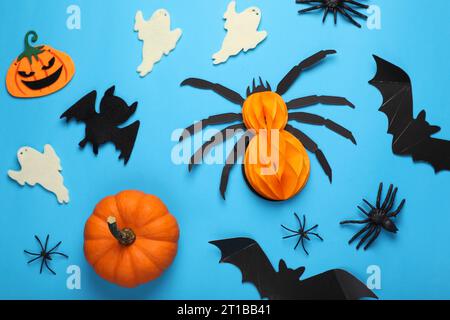 Composition de pose plate avec des chauves-souris, des citrouilles, des fantômes et des araignées sur fond bleu clair. Fête d'Halloween Banque D'Images