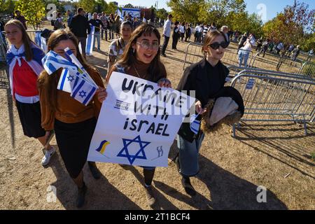 Bucarest, Roumanie. 12 octobre 2023 : jeunes femmes tenant une pancarte qui dit Ukraine avec Israël lors du rassemblement I Stand avec Israël organisé par l'ambassade israélienne près du Parlement roumain à Bucarest, où plusieurs centaines de personnes, principalement des membres des communautés israélienne et juive, montrez leur soutien à l’État israélien après les actes terroristes du Hamas tuant plus de 1200 civils innocents, plus de 3000 blessés et environ 150 enlevés, près de la bande de Gaza. Crédit : Lucian Alecu/Alamy Live News Banque D'Images
