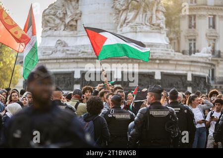 Paris, France. 12 octobre 2023. Des manifestants pro-palestiniens brandissent des drapeaux lors de la manifestation sur la place de la République. Malgré l’interdiction par le ministre français de l’intérieur, Gérald Darmanin, de toutes les manifestations pro-palestiniennes en France, plusieurs centaines de personnes se sont rassemblées sur la place de la République, à Paris, pour manifester leur soutien à la Palestine. La police a tenté d'arrêter la manifestation et de disperser la foule à l'aide de gaz lacrymogènes et de canons à eau. Crédit : SOPA Images Limited/Alamy Live News Banque D'Images