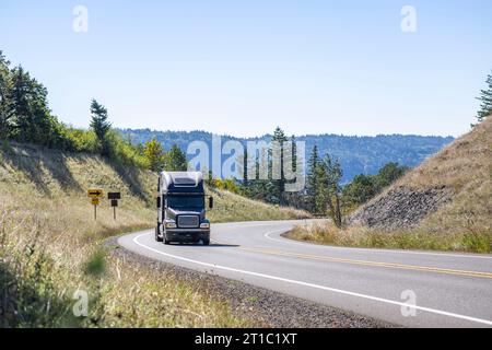 Tracteur semi-camion industriel long porteur noir BIG RIG avec cabine allongée pour le repos du conducteur de camion transportant des marchandises dans un camion sec semi-remorque cl Banque D'Images