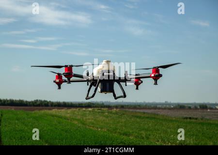 Drone agricole voler pour pulvériser de l'engrais sur les champs. Agriculture industrielle et agriculture intelligente Banque D'Images