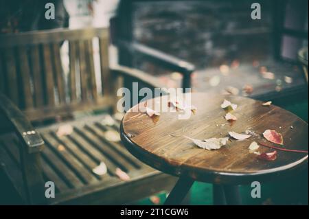 table en bois devant le fond flou abstrait de café de porte avec des feuilles d'automne Banque D'Images