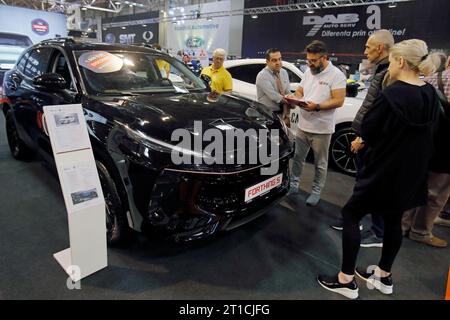 Bucarest, Roumanie. 12 octobre 2023. Les visiteurs regardent une voiture Forthing?5?lors de la 20e édition du Bucharest car Show 2023 (SAB) à Bucarest, Roumanie, le 12 octobre 2023. Plus de 40 entreprises internationales ont présenté leurs véhicules conventionnels, hybrides et électriques, ainsi que divers accessoires pour les voitures lors du salon. Crédit : Cristian Cristel/Xinhua/Alamy Live News Banque D'Images