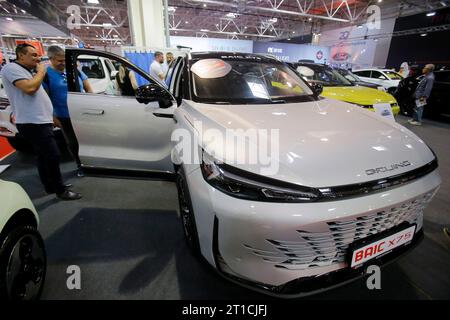 Bucarest, Roumanie. 12 octobre 2023. Les visiteurs regardent une voiture BAIC X75?lors de la 20e édition du Bucharest car Show 2023 (SAB) à Bucarest, Roumanie, le 12 octobre 2023. Plus de 40 entreprises internationales ont présenté leurs véhicules conventionnels, hybrides et électriques, ainsi que divers accessoires pour les voitures lors du salon. Crédit : Cristian Cristel/Xinhua/Alamy Live News Banque D'Images