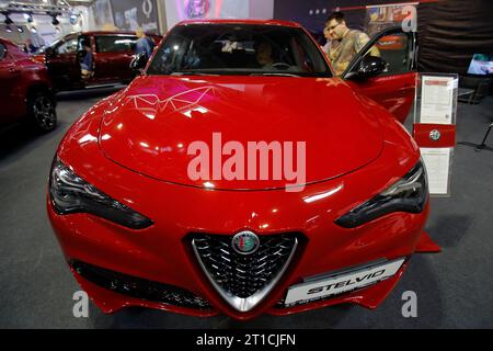 Bucarest, Roumanie. 12 octobre 2023. Les visiteurs regardent une Alfa?Romeo Stelvio?car?car?lors de la 20e édition du Bucharest car Show 2023 (SAB) à Bucarest, Roumanie, le 12 octobre 2023. Plus de 40 entreprises internationales ont présenté leurs véhicules conventionnels, hybrides et électriques, ainsi que divers accessoires pour les voitures lors du salon. Crédit : Cristian Cristel/Xinhua/Alamy Live News Banque D'Images