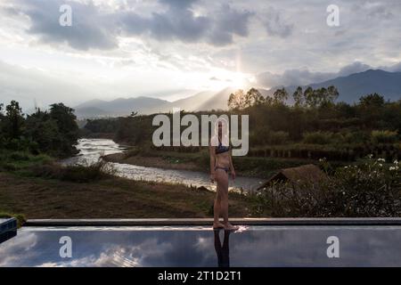 Femme adulte debout à côté de la piscine, Pai, Mae Hong Soon, Thaïlande Banque D'Images