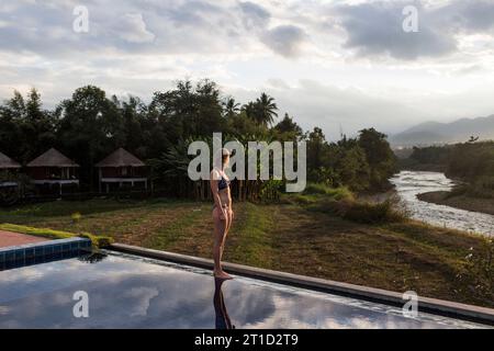 Femme adulte debout à côté de la piscine, Pai, Mae Hong Soon, Thaïlande Banque D'Images