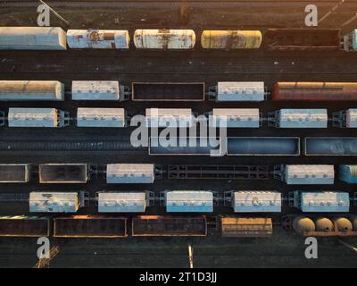 Vue aérienne de dessus de wagons de chemin de fer. Trains de marchandises au coucher du soleil Banque D'Images