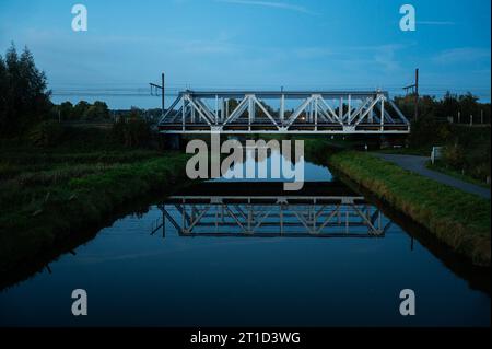 Pont sur la rivière Dender pendant l'heure bleue, Denderleeuw, région flamande orientale, Belgique Banque D'Images