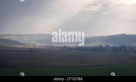 Paysage d'un village hongrois et des champs agricoles en automne, rayons de soleil couchant ciel nuageux, Nograd, Cserhatsurany (Nógrád megye, Cserhátsurány Banque D'Images