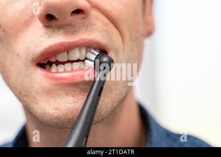 Augsbourg, Bavière, Allemagne. 13 octobre 2023. Homme se brossant les dents avec une brosse à dents électrique. Concept d'hygiène bucco-dentaire *** Mann putzt die Zähne mit einer elektrischen Zahnbürste. Mundhygiene Konzept crédit : Imago/Alamy Live News Banque D'Images