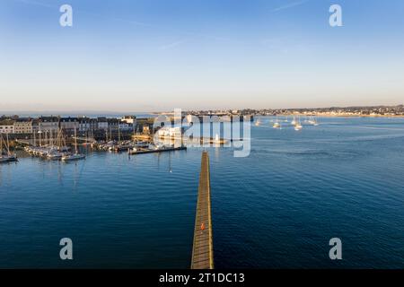 Port-Louis (Bretagne, nord-ouest de la France) : vue aérienne de l'embarcadère de la pointe de Kerzo et de la ville de Port-Louis en arrière-plan. Homme marchant a Banque D'Images