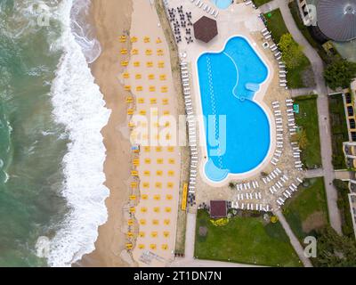 Une vue aérienne à couper le souffle d'un hôtel de luxe avec piscine en bord de mer, prêt à accueillir les clients en début de saison. Banque D'Images