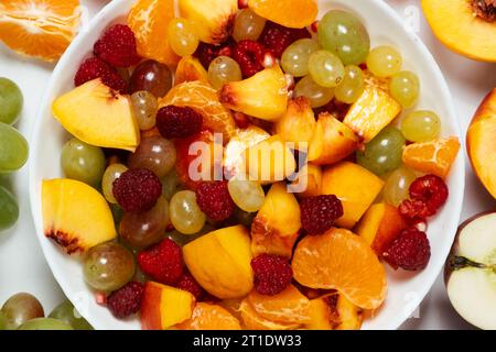 Salade de fruits avec fruits tranchés, raisins mélangés, framboises, nectarines, mandarines et pommes Banque D'Images