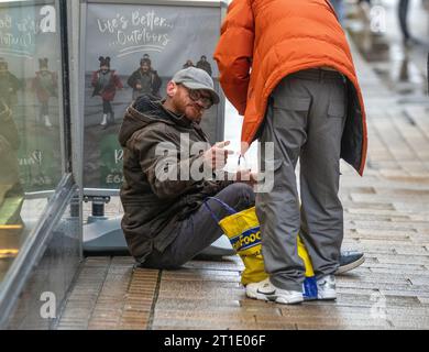 Affamés et sans abri dans le centre de Preston City, les travailleurs sociaux, assistés par la police, et les passants apportent de la nourriture, des boissons et des couvre-lits aux dormeurs rudes de la ville. Banque D'Images
