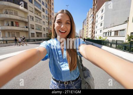 Jeune belle femme brésilienne avec vêtements élégants prend l'autoportrait sur l'autoroute Minhocao dimanche à Sao Paulo, Brésil Banque D'Images