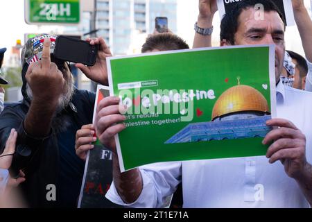 Tokyo, Japon. 13 octobre 2023. Un manifestant portant un chapeau Trump 2024 flippe la presse lors d'un rassemblement pro-palestinien derrière un homme avec un signe prônant la paix et la réconciliation. Des membres de la communauté islamique au Japon et des partisans japonais protestent devant l'ambassade israélienne en solidarité avec la Palestine et contre Israël au début la guerre dans la bande de Gaza après que le groupe militant du Hamas a lancé une attaque d'incursion terrestre en Israël. Israël et l'armée israélienne ont commencé à amasser des troupes à la frontière et ont mis un siège à la bande de Gaza en bloquant la nourriture, l'électricité et l'eau. (Image de crédit : Banque D'Images