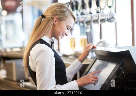 Caissier, barista et jeune serveuse au café vérifiant le reçu de paiement. Hospitalité, serveur et majordome féminin du Canada préparant un bordereau à Banque D'Images