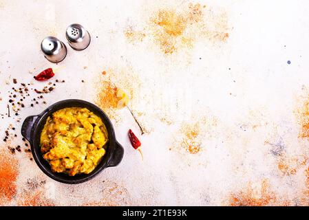 Curry de poulet ou masala, curry de poulet de style Kerala utilisant de la noix de coco frite de manière traditionnelle et disposé dans un récipient en céramique noire Banque D'Images