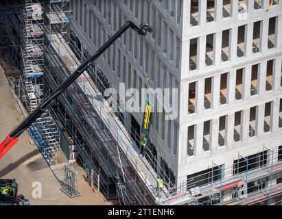 Vitrier installant des fenêtres sur un bâtiment commercial. Banque D'Images