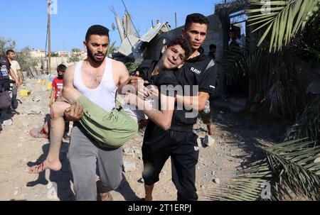 Rafah, Gaza. 13 octobre 2023. Des Palestiniens transportent une personne blessée lors d’une frappe aérienne israélienne à Rafah, dans le Sud de la bande de Gaza, le vendredi 13 octobre 2023. Photo par Ismael Mohamad/UPI crédit : UPI/Alamy Live News Banque D'Images