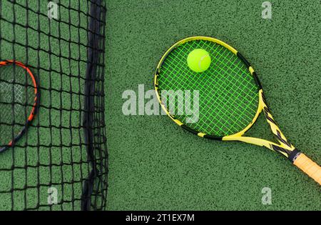 Deux raquettes de tennis près du filet avec une balle Banque D'Images