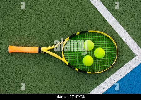 raquette de tennis avec 3 balles dans le coin du court Banque D'Images