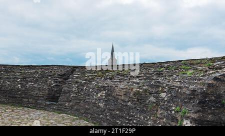 Angers, France, 2023. Le toit du clocher de l'église Saint-Laud vu des créneaux de pierre et d'ardoise du Château d'Angers Banque D'Images