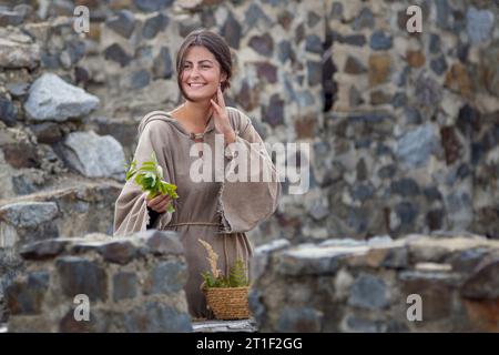 Femme de marché assez sympathique au Moyen âge vend des herbes Banque D'Images