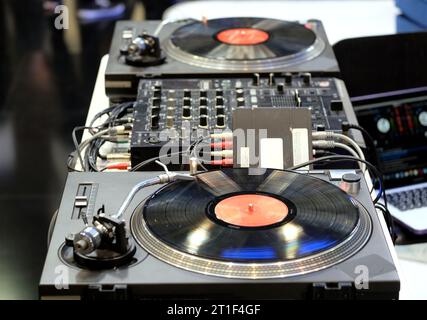 Console DJ moderne avec deux lecteurs de vinyle avec disques, mélangeurs et fils de connexion dans la boîte de nuit vue rapprochée Banque D'Images