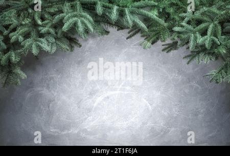 Fond de Noël élégant simple avec des branches de sapin frais formant une arche sur la texture grise faite à la main comme espace de copie avec projecteur et vignette Banque D'Images