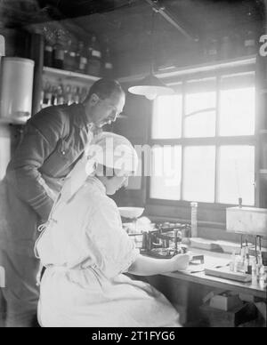 L'Edis Olive, photographe de l'IWM Women's Services en France 1919, un médecin et une infirmière de l'armée (le Dr Patterson et Mlle Nord) travaillant à couper une section pour le test à un banc au 25e hôpital stationnaire à Rouen. Banque D'Images